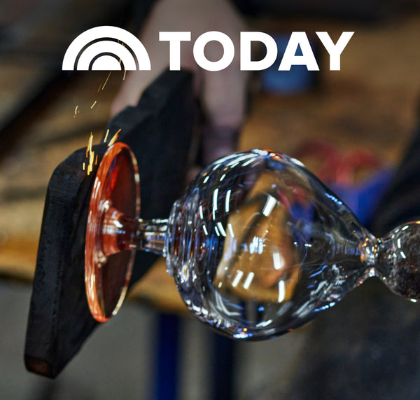 The TODAY Show feature: A glassblower shaping a molten handblown glass piece on a blowpipe in Simon Pearce's workshop, with sparks and glowing orange glass visible