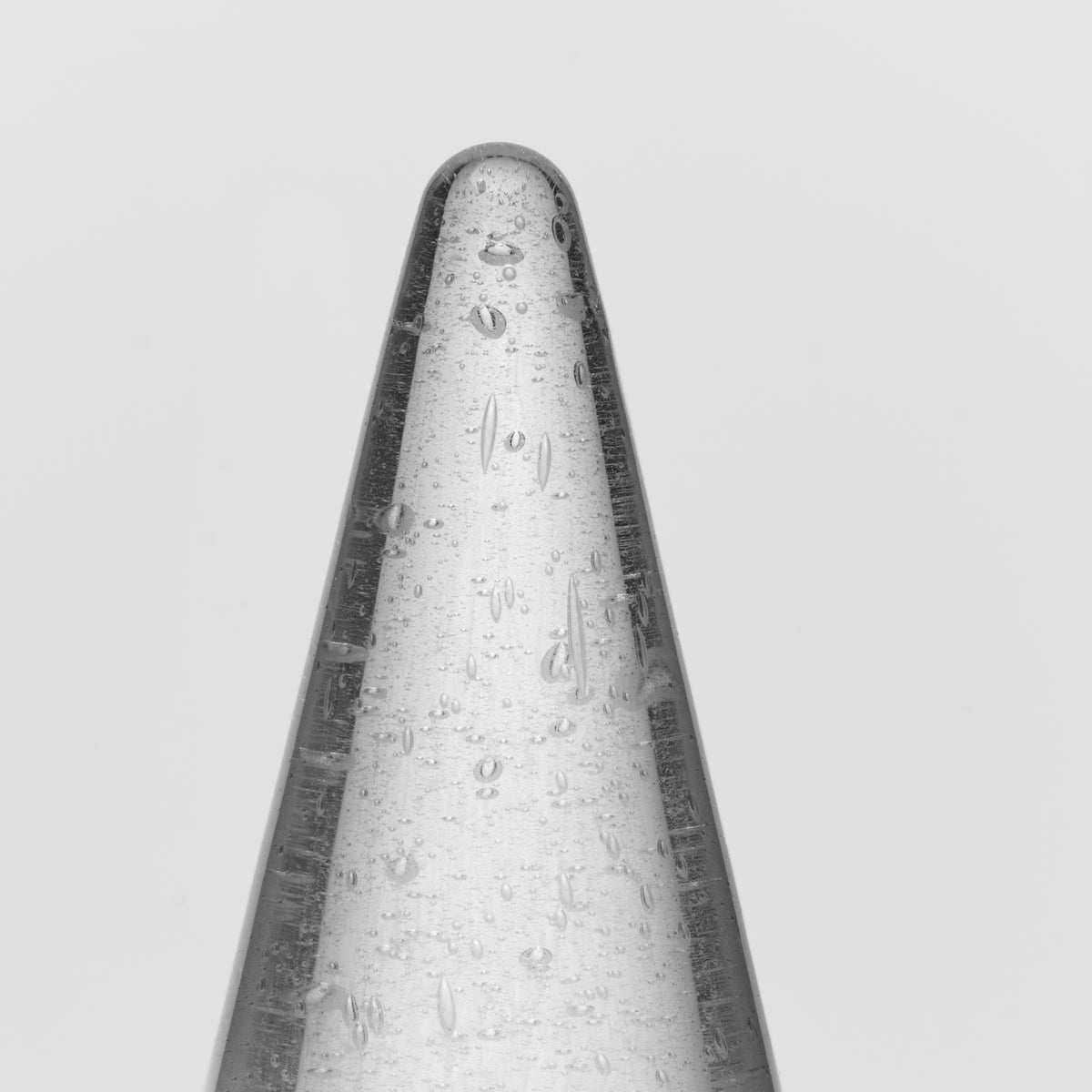 Tall conical candle with white and dark gray coloring and textured surface details.
