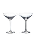 Two clear coupe glasses with wide bowls and thin stems on white background.