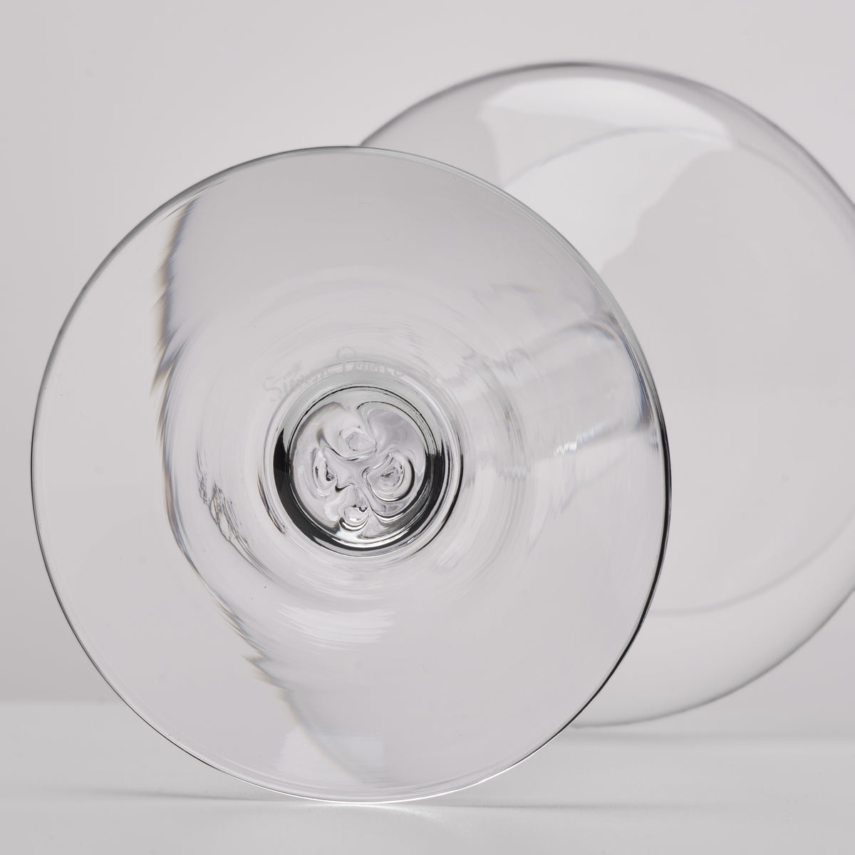 A clear glass shown from the bottom on a light gray background.