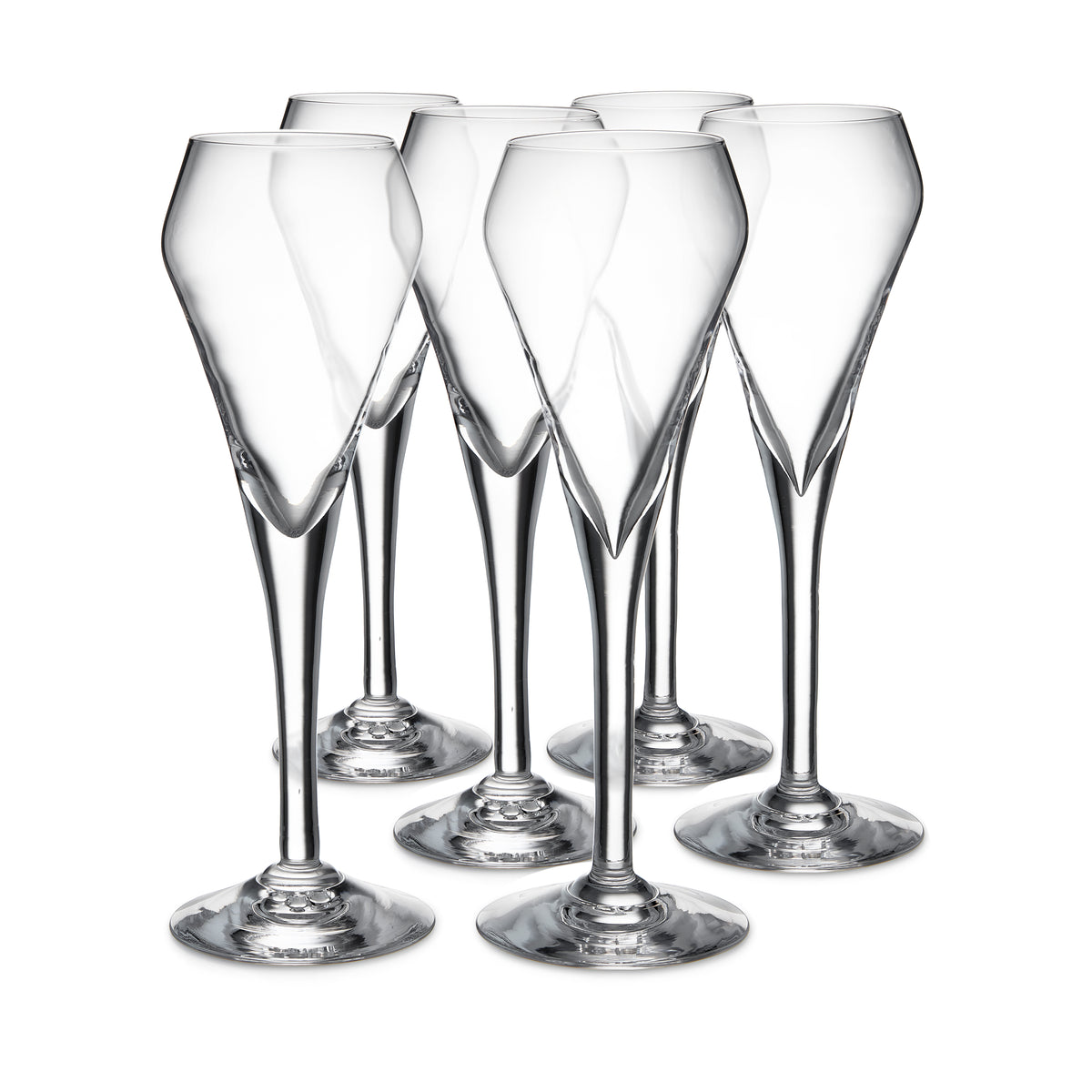 Six clear glass flutes with tapered bowls and solid bases arranged in a group.