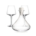 Glass wine decanter with white stopper and two matching wine glasses.