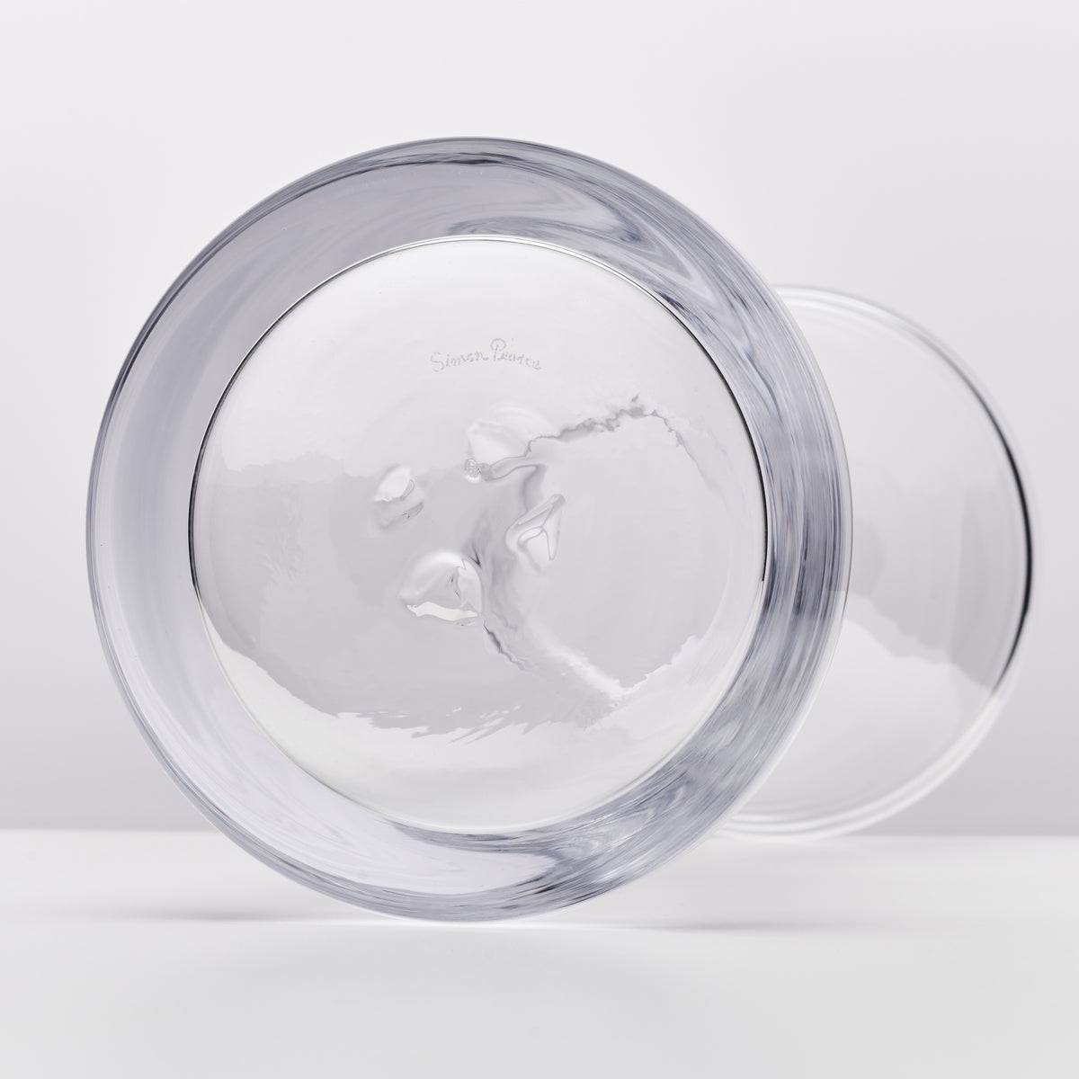 Two clear glass bowls with gray-tinted rims, one shown from above with visible interior texture and one behind it.