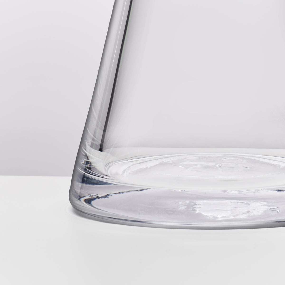 Clear glass bowl with wide rim and tapered sides containing water.