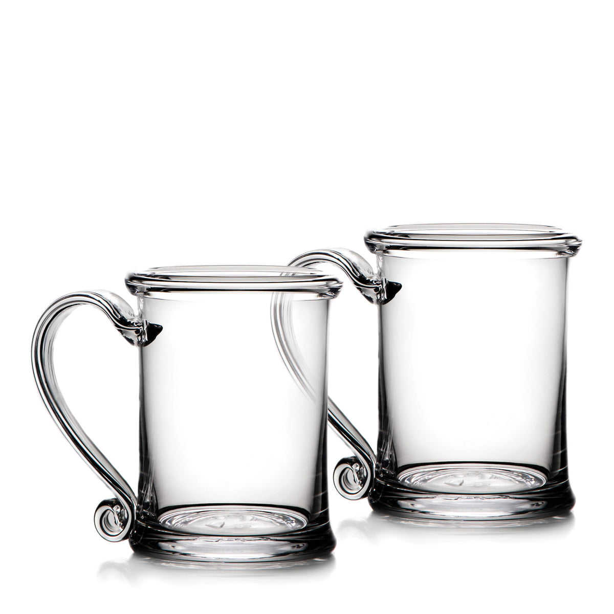 Two clear glass tankards with handles and circular base medallions.