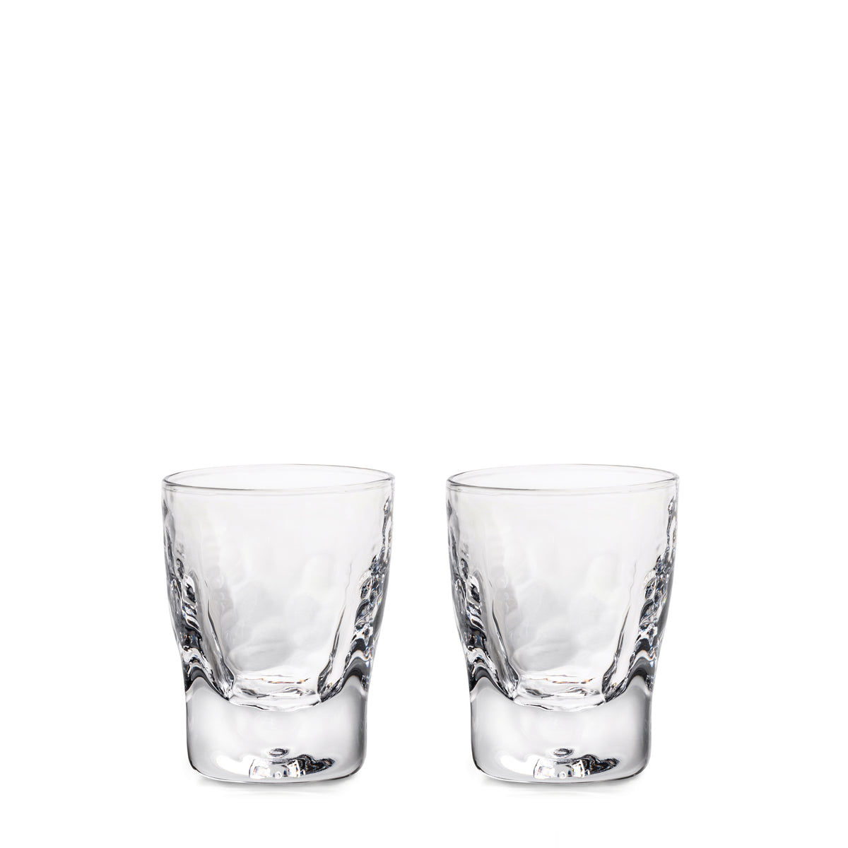 Two clear glass shot glasses with textured sides and reinforced bases.