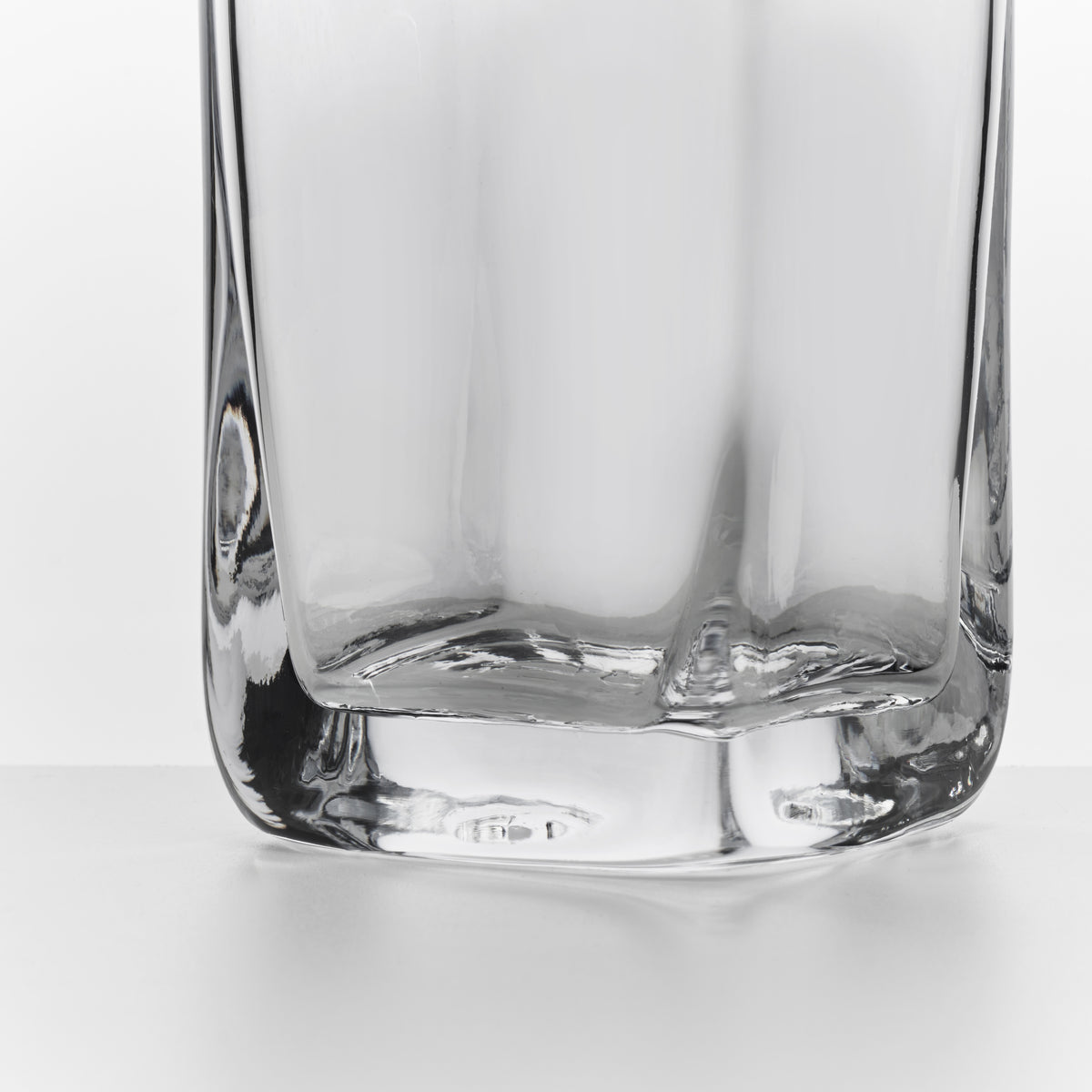 Clear glass cocktail carafe with squared sides and flat bottom.