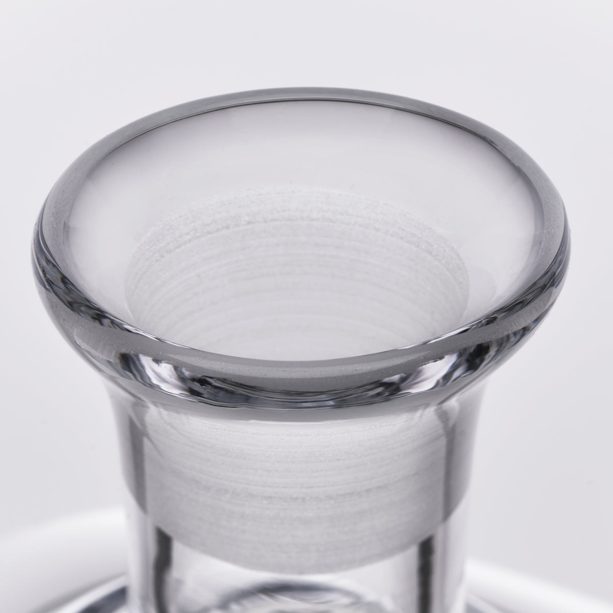 Clear glass decanter with wide flared rim and cylindrical body, shown against a light background.