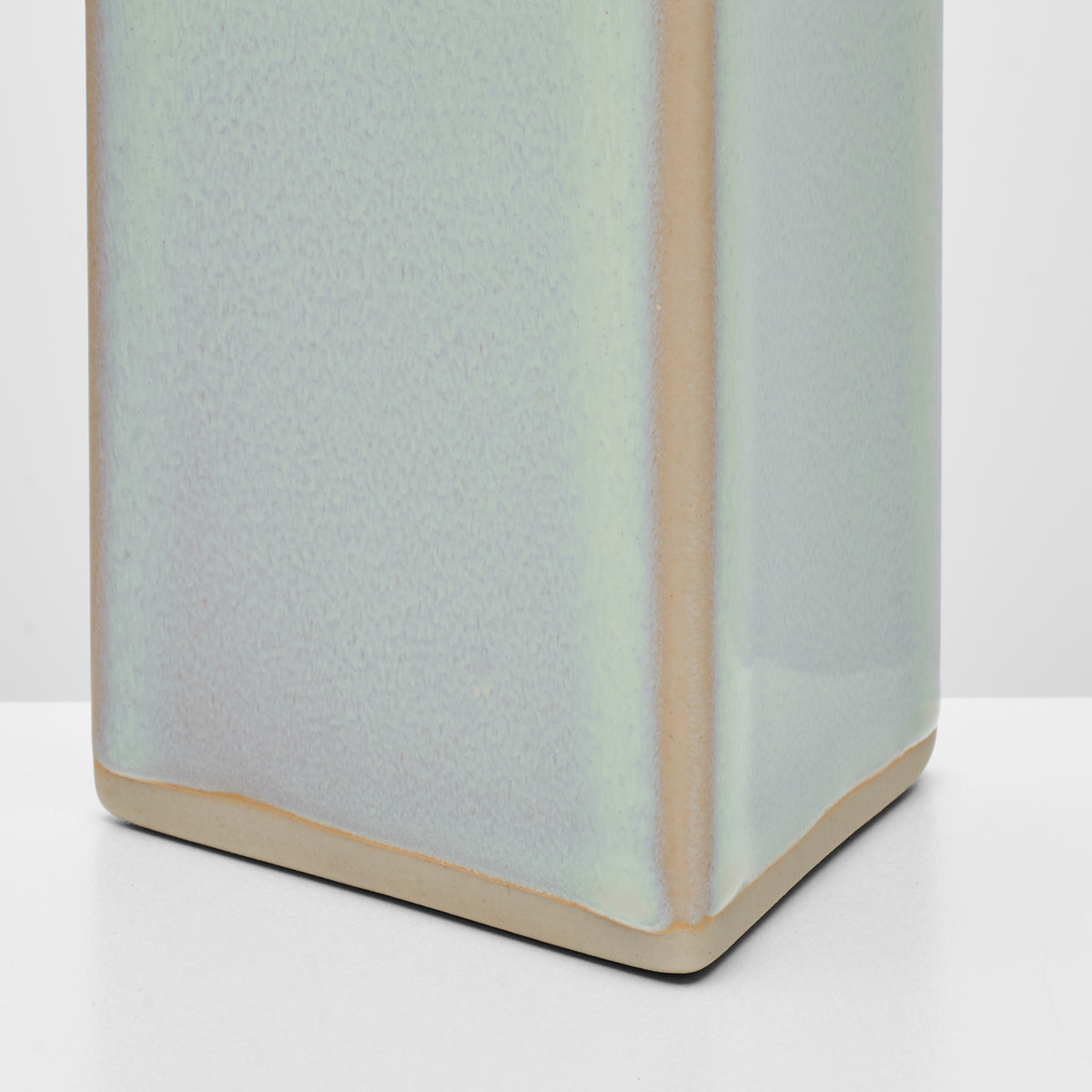 Rectangular pottery taper holder in sage green with natural clay base and sides.