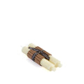 Two cream-colored tapered candles with brown wicks bundled together with a black label band.