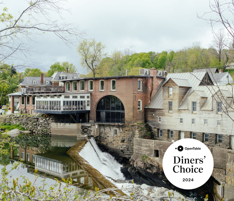 Exterior view of the Simon Pearce Restaurant at the historic Quechee Mill, with the Ottauquechee River waterfall below and an OpenTable Diners' Choice 2024 badge