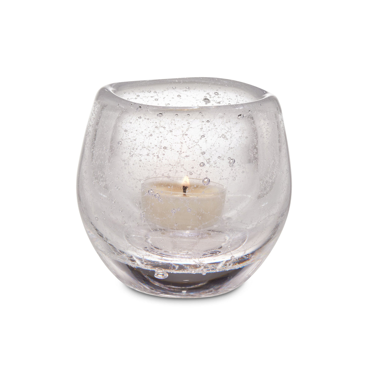 Clear glass tealight holder with cream-colored tealight candle inside and speckled texture on exterior.